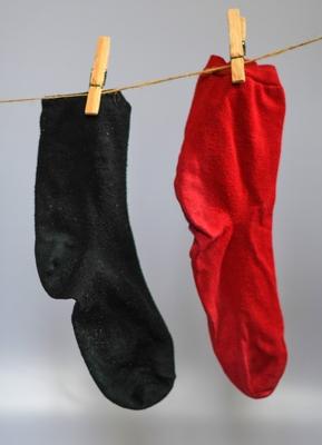 Eine rote und eine schwarze Socke h?ngen an einer W?scheleine. Vor zw?lf Monaten u ist die schwarz-rote Regierung verei-stock-photo