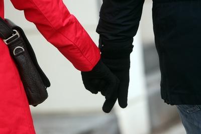 Symbolbild Gro?e Koalition zwischen CDU und SPD: rot-schwarz gekleidetes Paar geht H?ndehalten d in der Innenstadt M?nc-stock-photo