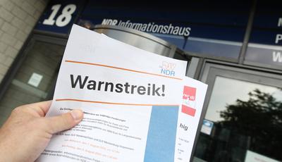 Ein Mann h?lt vor dem Eingang zum Informationshaus des Norddeutschen Rundfunks auf dem Gel?nde am Hugh-Green-Weg in Loks-stock-foto