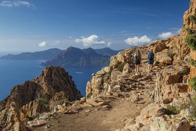 zwei Wanderer laufen in der Calanche einer bizarre Felsenlandschaft an der Suedkueste des Golfs von Porto im Regionalen-stock-foto
