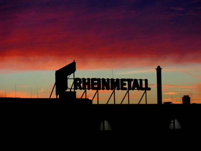 Blick auf das Firmenlogo von Rheinmetall auf der Fertigungsstaette am Hafenbecken eins in Neuss Sonnenaufgang ueber Rhei-stock-foto