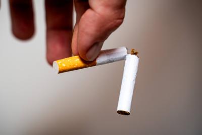 Bavaria, Germany - November 9, 2024: A man holds a broken cigarette as a symbol for quitting smoking *** Ein Mann h?lt e-stock-foto
