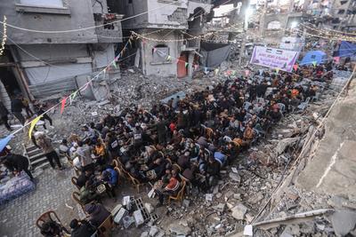 Palestinians break their fast with iftar meals during the holy month of Ramadan, near the rubble of buildings, amid a ceasefire between Israel and Hamas, in Beit Lahia-stock-foto