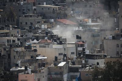 An Israeli military bulldozer demolishes Palestinian homes in the Nur Shams refugee camp east of Tulkarm-stock-photo
