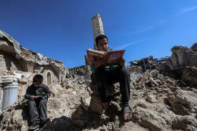 Muslim worshippers read from the Holy Quran as they sit at the historic Al-Omari Mosque in Gaza City on the second day of the holy month of Ramadan-stock-foto