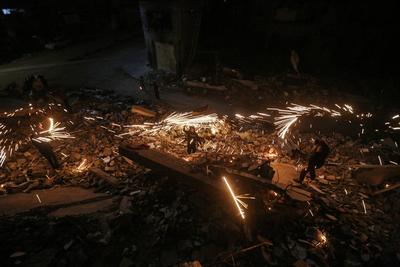 Palestinian youths light fireworks near the ruins of a building to celebrate the second day of the holy month of Ramadan in the Al-Rimal neighborhood in central Gaza City-stock-foto