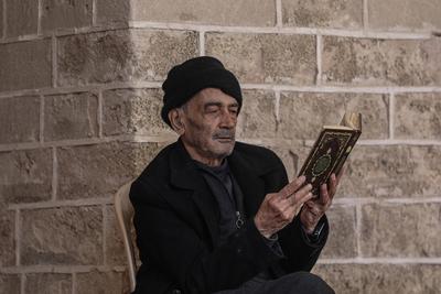 Muslim worshippers read from the Holy Quran as they sit at the historic Al-Omari Mosque in Gaza City on the second day of the holy month of Ramadan-stock-foto