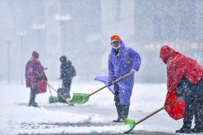 JINAN, CHINA - MARCH 02: Sanitation workers clear snow from the road at Jinan West Railway Station on March 2, 2025 in J-stock-foto