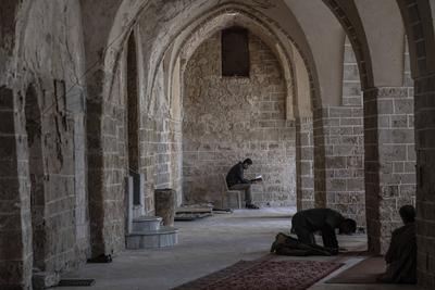 Muslim worshippers read from the Holy Quran as they sit at the historic Al-Omari Mosque in Gaza City on the second day of the holy month of Ramadan-stock-foto