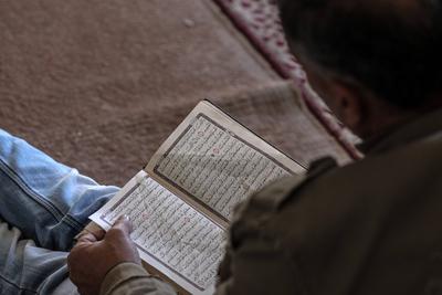 Muslim worshippers read from the Holy Quran as they sit at the historic Al-Omari Mosque in Gaza City on the second day of the holy month of Ramadan-stock-foto