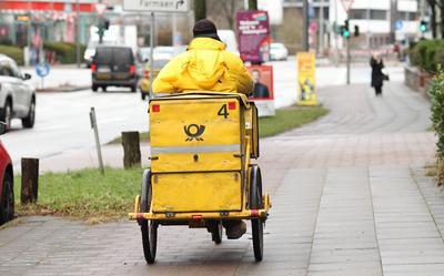 Ein Briefzusteller der Deutschen Post f?hrt mit seinem Fahrrad auf einem Gehweg entlang. Wandsbek Hamburg *** A Deutsche-stock-foto