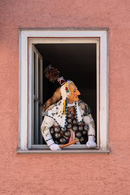 Ein Bi?, eine Rottweiler Narrenfigur, schaut w?hrend des Narrensprungs aus einem Fenster eines Hauses. Der Rottweiler Na-stock-foto