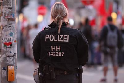 Eine Polizistin steht w?hrend einer Demonstration am Stra?enrand. Altstadt Hamburg *** A policewoman stands on the side-stock-foto