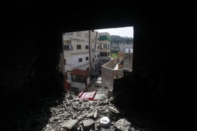 Palestinians inspect an apartment that was targeted by an Israeli air strike in the eastern neighborhood of Jenin-stock-photo