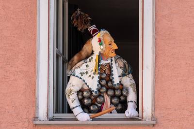 Ein Bi?, eine Rottweiler Narrenfigur, schaut w?hrend des Narrensprungs aus einem Fenster eines Hauses. Der Rottweiler Na-stock-foto