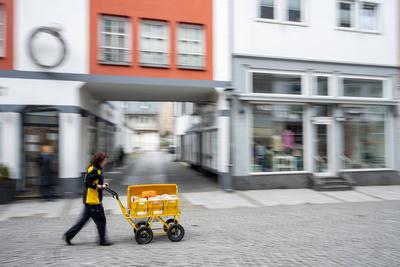 Deutsche Post Mitarbeiterin mit Postwagen in Fu?g?ngerzone 19.02.24, Limburg: Symbolfoto, Illustrationsbild, Symbolbild,-stock-foto
