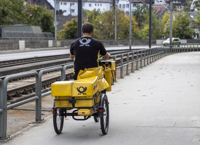 Brieftr?ger der Deutsche Post unterwegs auf seinem Dienstfahrrad. // 21.10.2022: DEU, Deutschland, Baden-W?rttemberg, St-stock-foto