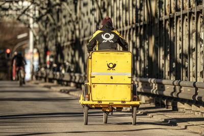 Postbote mit gelbem Dienstfahrrad auf der Hackerbr?cke, M?nchen, Januar 2025-stock-photo