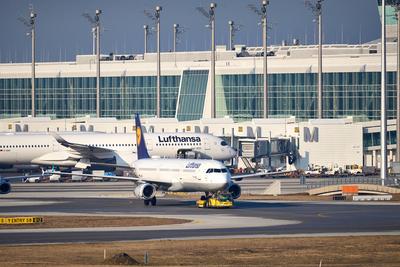 Munich, Bavaria, Germany - February 20, 2025: A Lufthansa Airbus A321 is moved with an aircraft tug at Munich Airport, w-stock-foto