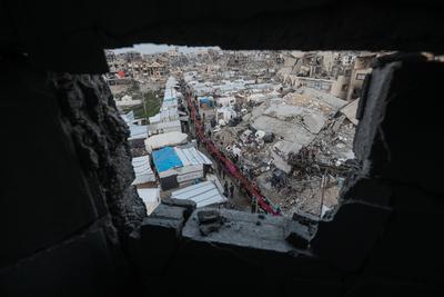 Palestinians gather among destroyed buildings to break their fast together during the holy month of Ramadan in Jabalia camp, northern Gaza Strip-stock-foto