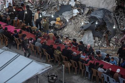 Palestinians gather among destroyed buildings to break their fast together during the holy month of Ramadan in Jabalia camp, northern Gaza Strip-stock-foto