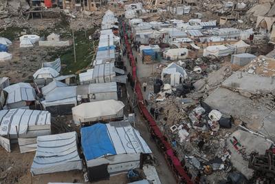 Palestinians gather among destroyed buildings to break their fast together during the holy month of Ramadan in Jabalia camp, northern Gaza Strip-stock-foto