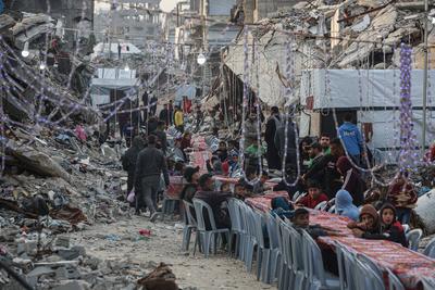 Palestinians gather among destroyed buildings to break their fast together during the holy month of Ramadan in Jabalia camp, northern Gaza Strip-stock-foto