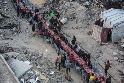 Palestinians gather among destroyed buildings to break their fast together during the holy month of Ramadan in Jabalia camp, northern Gaza Strip-stock-foto
