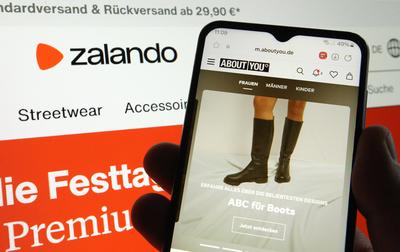 Auf einem Laptop wurde die Website vom Online-Versandh?ndler Zalando ge?ffnet. Davor wurde auf einem Smartphone die Webs-stock-foto