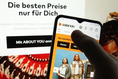 Auf einem Laptop wurde die Website vom Interneth?ndler About You ge?ffnet. Davor wurde auf einem Smartphone die Website-stock-foto