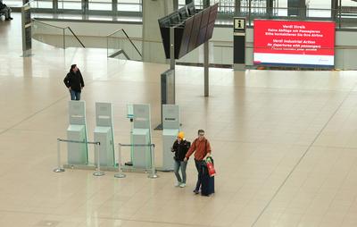Ein Mann und eine Frau gehen w?hrend des Warnstreiks der Besch?ftigten am Hamburger Flughafen, die unter den Tarifvertra-stock-foto