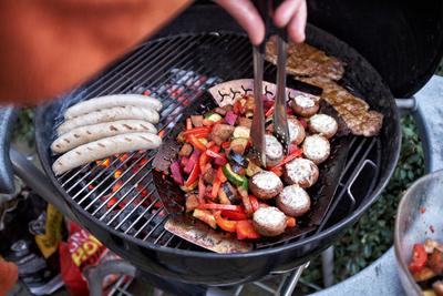 Grillen Auf einem Rundgrill werden gleichzeitig Wuerstchen, Steaks und Gemuese gegrillt. Essen NRW *** Barbecue at a Rou-stock-foto