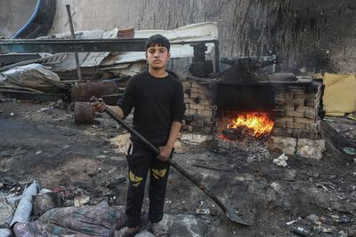 Palestinian workers pours out processed fuel from recycled plastic in Gaza City-stock-foto