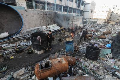 Palestinian workers pours out processed fuel from recycled plastic in Gaza City-stock-foto