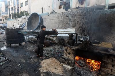 Palestinian workers pours out processed fuel from recycled plastic in Gaza City-stock-foto