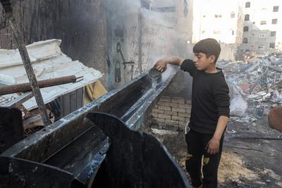 Palestinian workers pours out processed fuel from recycled plastic in Gaza City-stock-foto