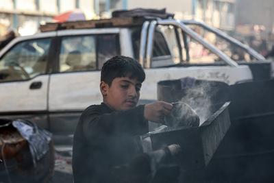 Palestinian workers pours out processed fuel from recycled plastic in Gaza City-stock-foto