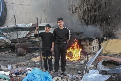 Palestinian workers pours out processed fuel from recycled plastic in Gaza City-stock-foto