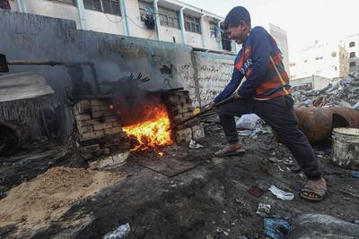 Palestinian workers pours out processed fuel from recycled plastic in Gaza City-stock-foto