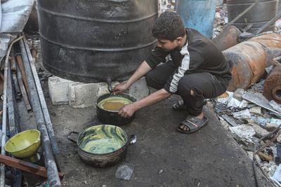 Palestinian workers pours out processed fuel from recycled plastic in Gaza City-stock-foto