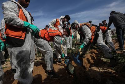 The bodies of the Palestinian martyrs, who were killed during raids by the Israeli occupation army and buried in a mass grave in Al-Shifa Hospital due to the siege at the time, were exhumed for identification and burial in the official cemeteries in Gaza-stock-foto