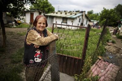 Eine Frau steht am Zaun ihres Grundstuecks in einer Romasiedlung in Belgrad. Belgrad, 28.05.2015. Belgrad Serbien PUBLI-stock-foto