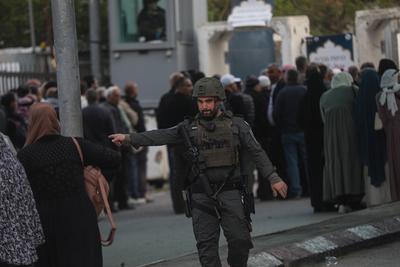 Palestinian Muslims wait in a line to cross an Israeli checkpoint in Bethlehem, in the occupied West Bank-stock-foto