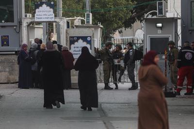 Palestinian Muslims wait in a line to cross an Israeli checkpoint in Bethlehem, in the occupied West Bank-stock-foto