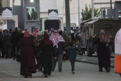 Palestinian Muslims wait in a line to cross an Israeli checkpoint in Bethlehem, in the occupied West Bank-stock-foto