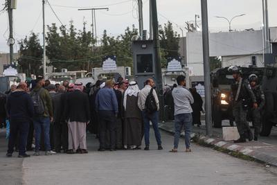 Palestinian Muslims wait in a line to cross an Israeli checkpoint in Bethlehem, in the occupied West Bank-stock-foto