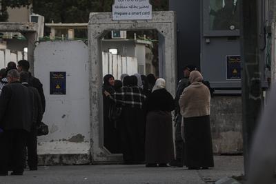 Palestinian Muslims wait in a line to cross an Israeli checkpoint in Bethlehem, in the occupied West Bank-stock-foto