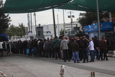 Palestinian Muslims wait in a line to cross an Israeli checkpoint in Bethlehem, in the occupied West Bank-stock-foto
