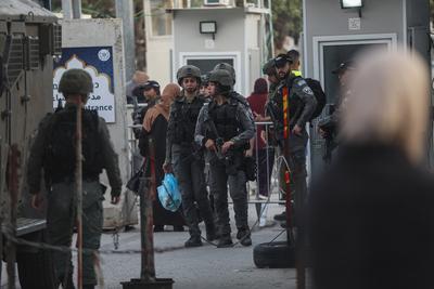 Palestinian Muslims wait in a line to cross an Israeli checkpoint in Bethlehem, in the occupied West Bank-stock-foto