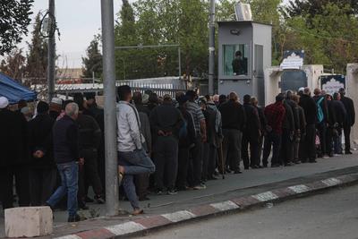 Palestinian Muslims wait in a line to cross an Israeli checkpoint in Bethlehem, in the occupied West Bank-stock-foto